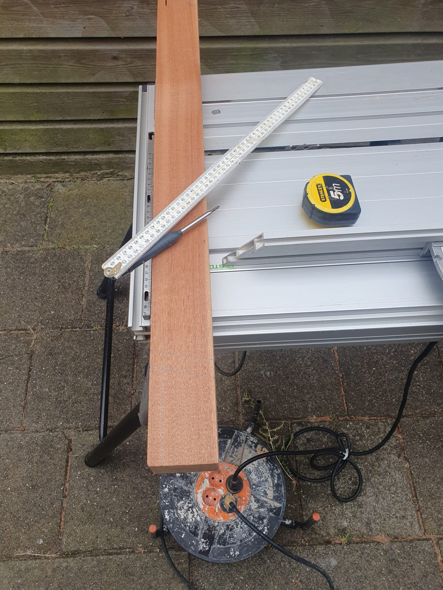 Hardhouten lat afgetekend op een zaagtafel voor houtrotherstel