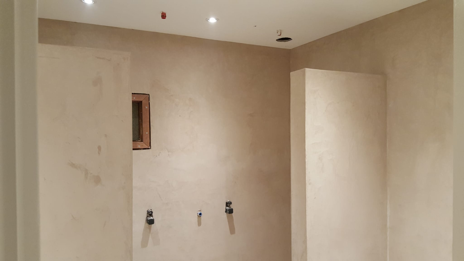 Badkamer met kalkstuc wanden, inbouwnis en spots