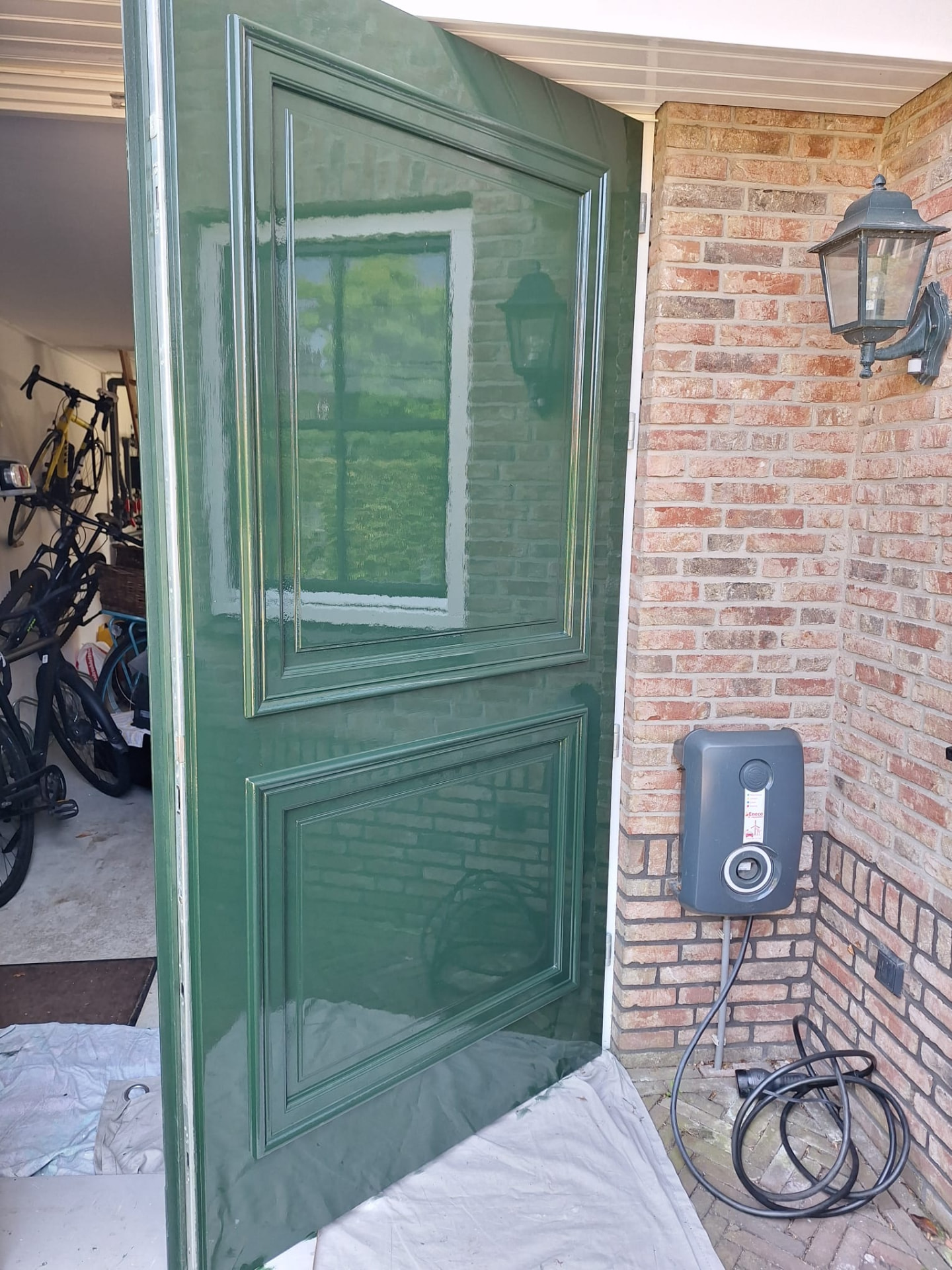 Detail van hoogglans groen lakwerk op een deur met spiegeling