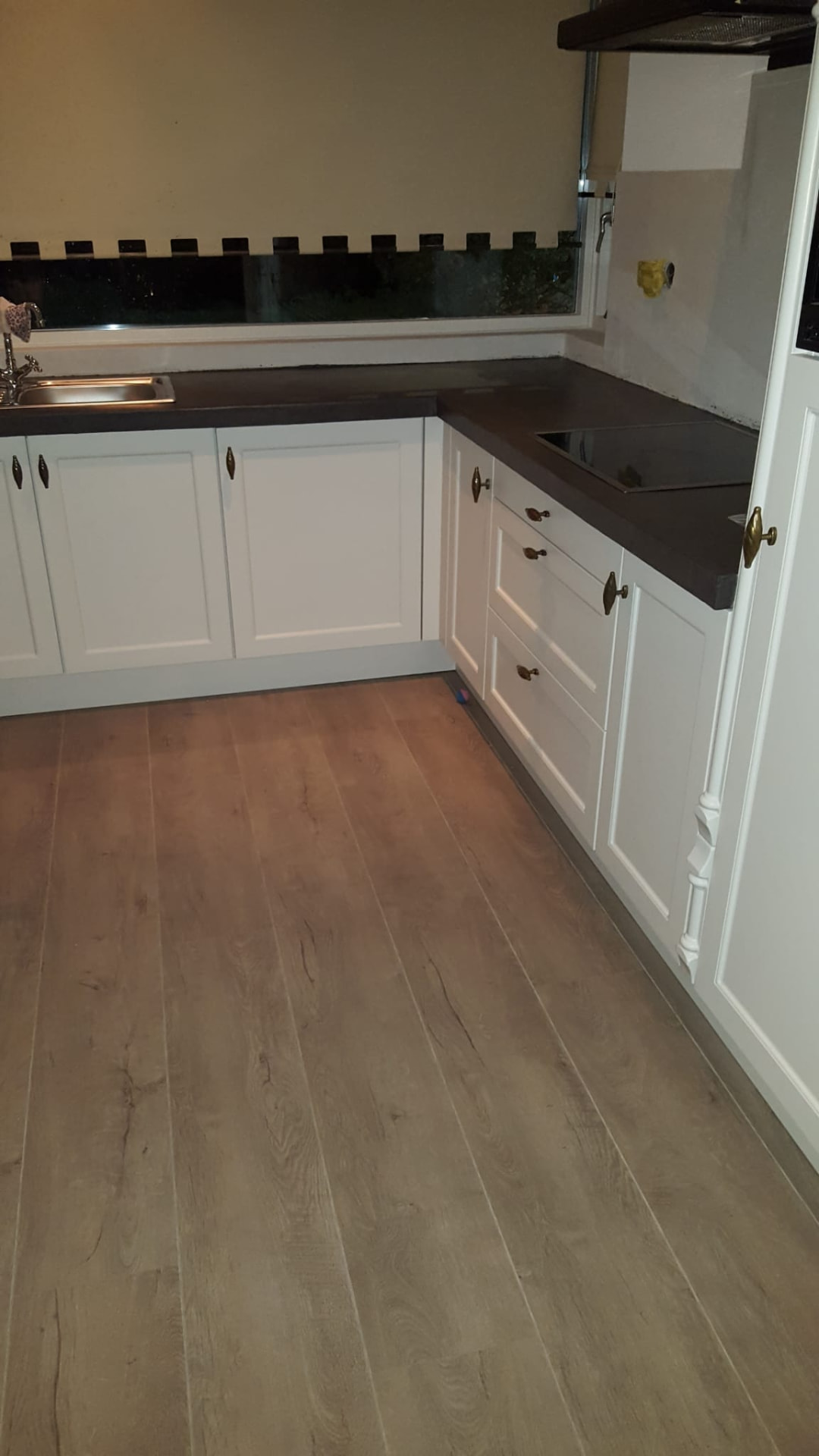 Moderne keuken met wit gespoten fronten en donker blad