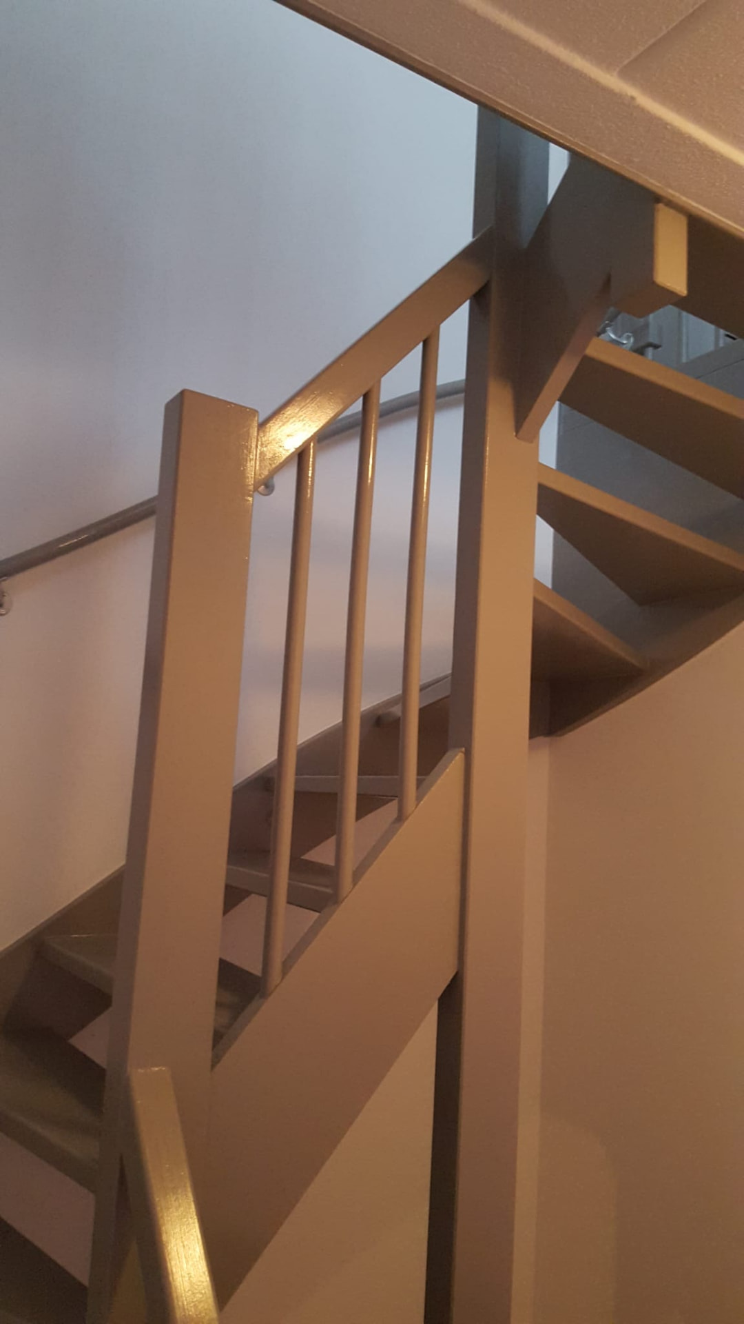 Detail van een gelakte trapleuning en balusters