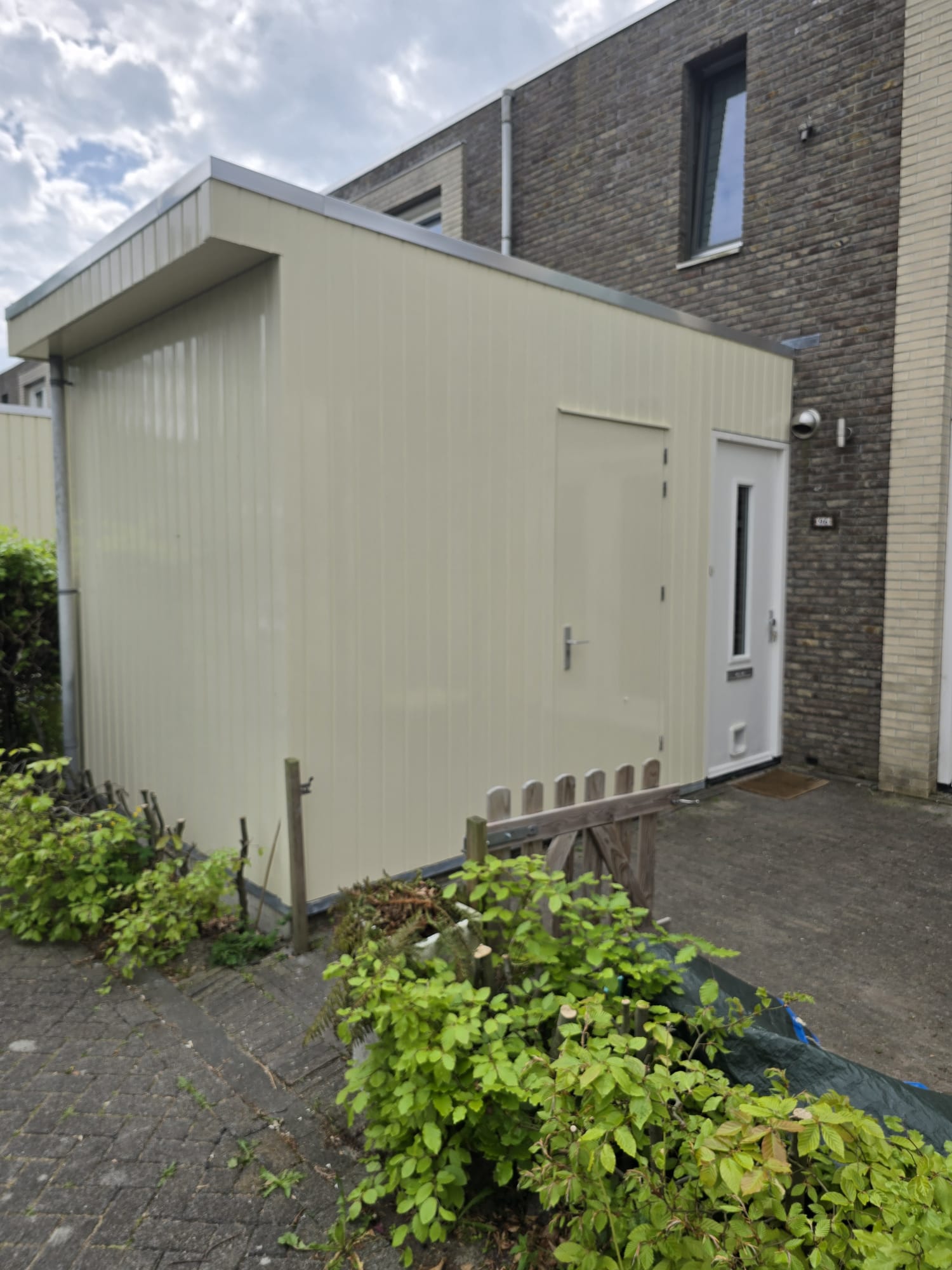 Geschilderde houten gevelbekleding van een berging in een lichte kleur