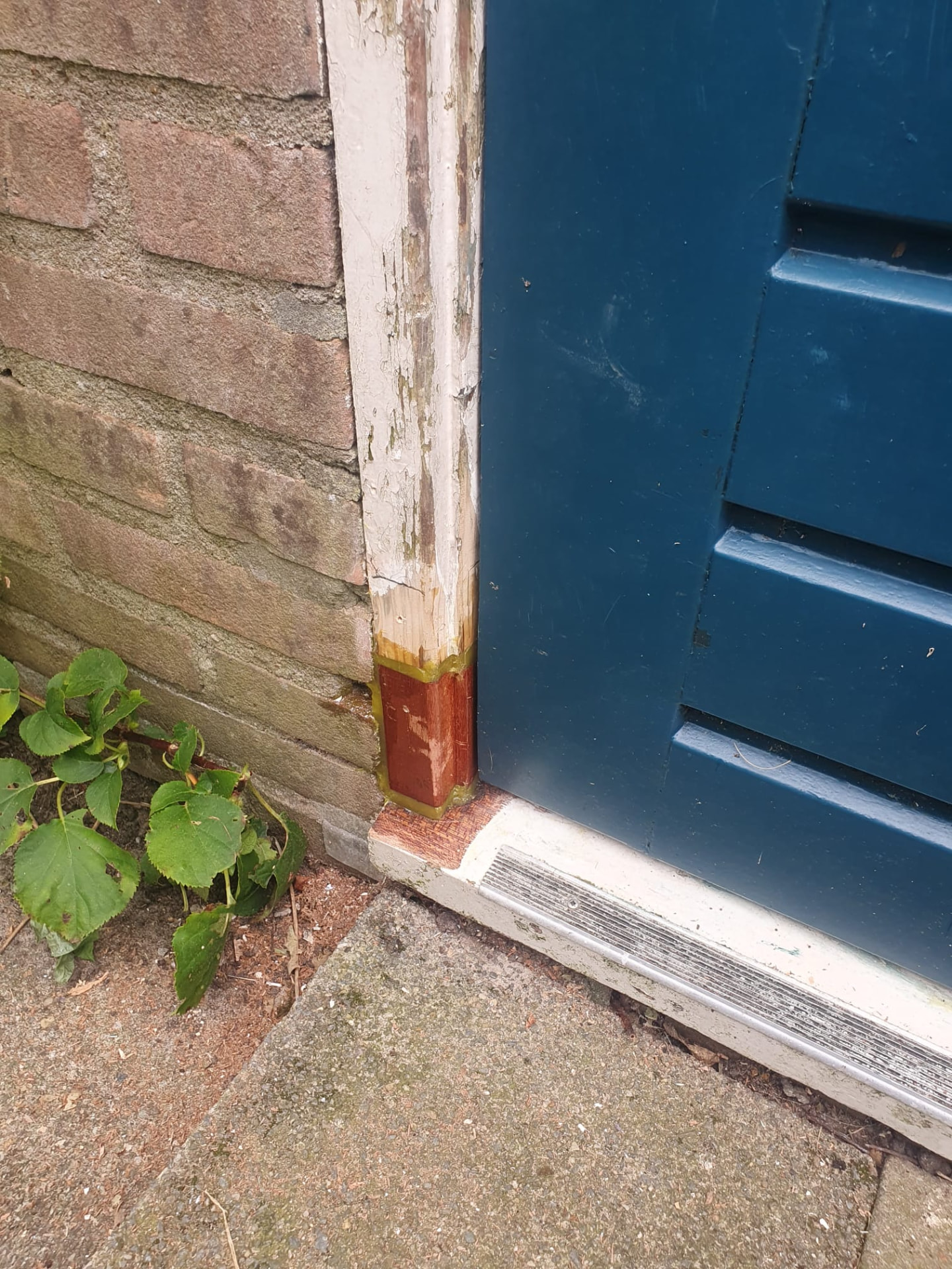 Detail van een met epoxy ingezet hardhouten deel in een deurkozijn