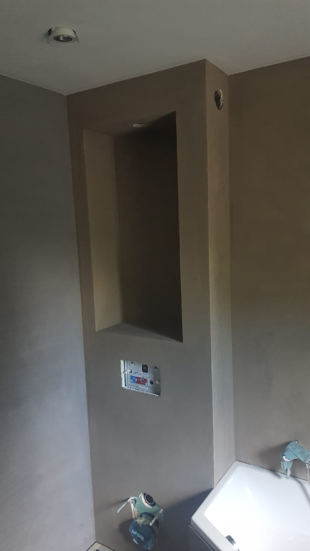 Betoncire douchewand met inbouwnis in een taupe tint