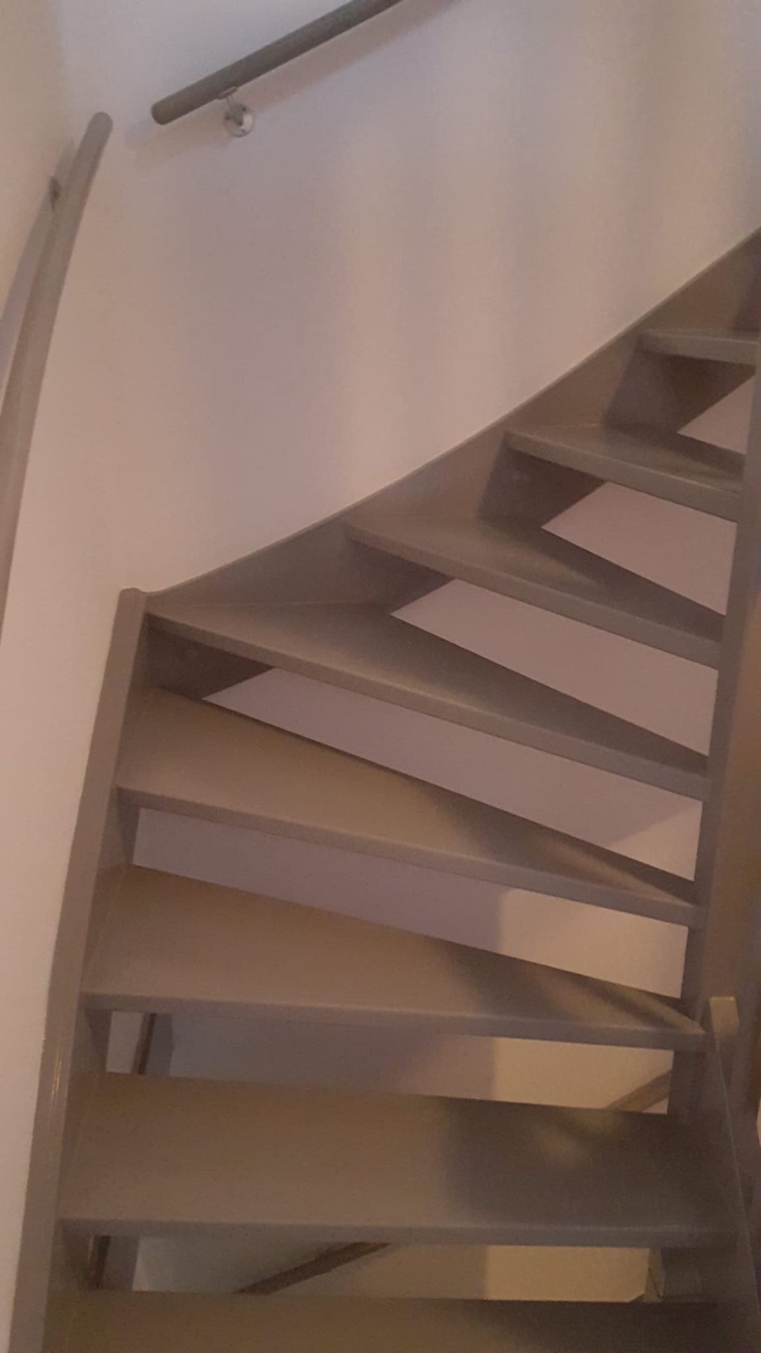 Binnenschilderwerk: strak gelakte houten trap met balustrade in een woning in Utrecht